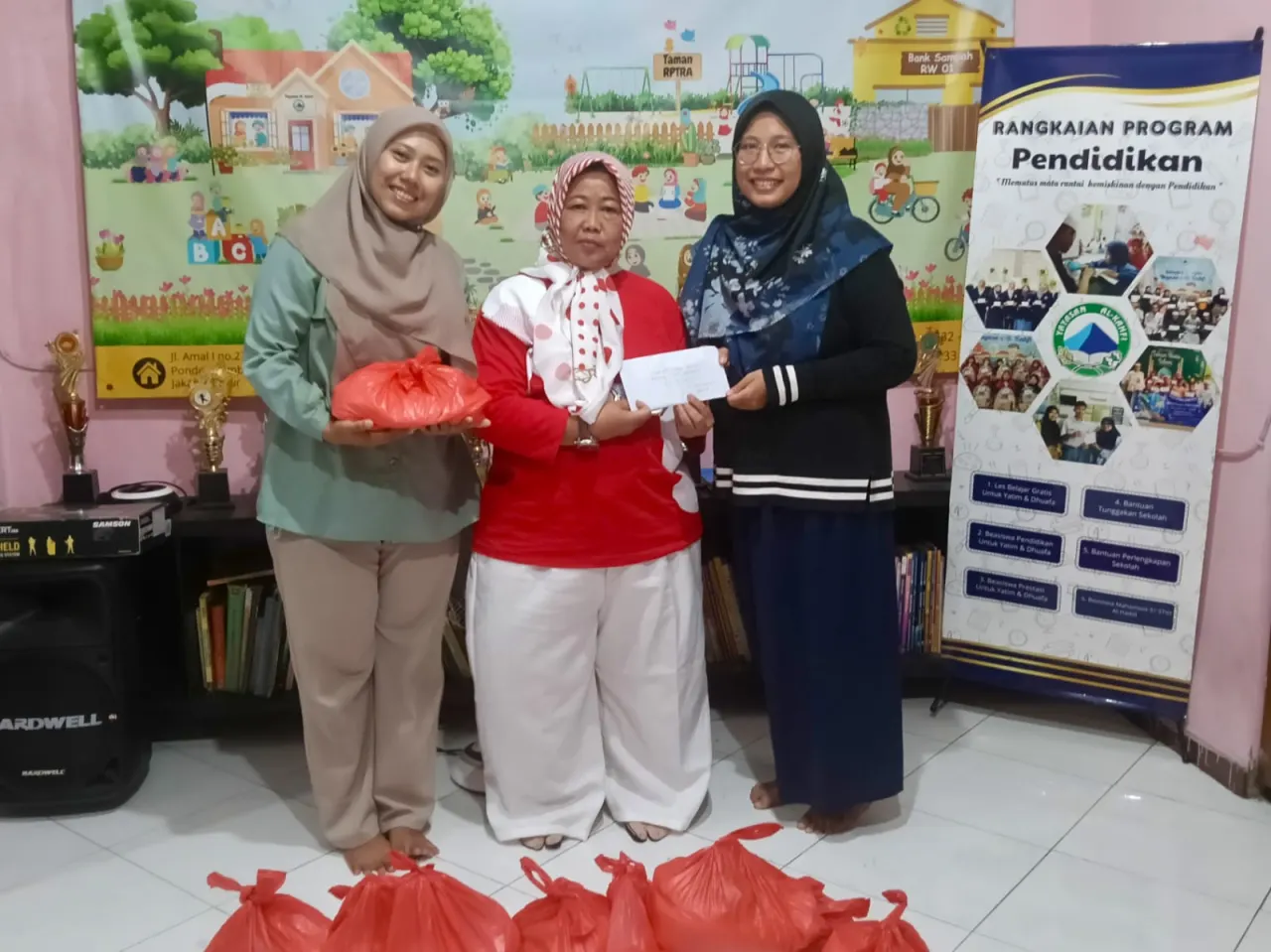 Pemimpin Redaksi Sudut Pandang Umi Sjarifah menyerahkan bantuan kepada anak yatim dan dhuafa dalam kegiatan Jumat Berkah rangkaian HUT ke-11 Sudut Pandang, Jumat (28/8/2026).